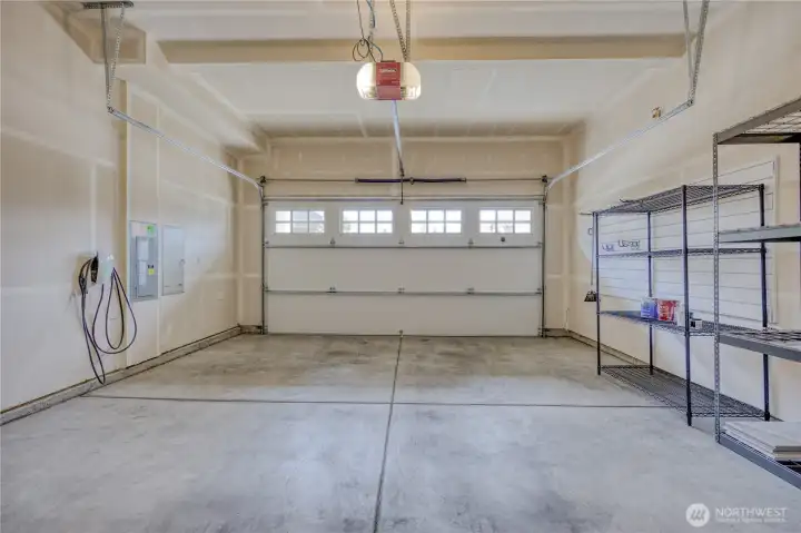 2 car garage with Tesla level 2 charger and 2 steel shelves that stay.