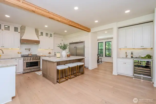 From the slider you have a great view of the gorgeous gourmet kitchen in all her glory! Stunning quartzite counters, large eat-in island with built-in microwave and tons of soft close storage drawers & cabinetry. High-end, professional appliances make cooking and baking a joy!
