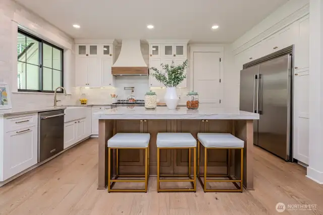 Love the custom cabinetry, the large farmhouse sink, the pot filler and the 60" Frigidaire Professional Refrigerator/Freezer with water dispenser & ice maker!  Extra pantry cabinetry flanks the fridge on both sides.  This is definitely a chef inspired kitchen! And imagine the view of kids throwing the football or jumping on the trampoline from the window above the kitchen sink!