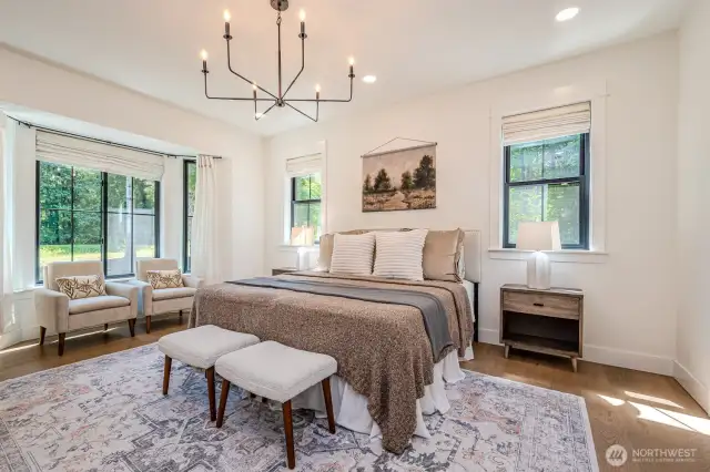 Luxurious Primary Suite with bay windows and soft, elegant finishes. Wake every morning to peaceful, serene front yard views and the quiet sounds of nature.