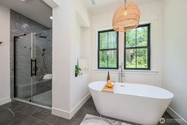 Everything about this space invites rest and relaxation.  Imagine soaking in the gorgeous 67" free-standing tub while enjoying serene backyard views or stepping into the grand walk-in shower with full tile surround, glass enclosure, dual rain shower heads and wands, built-in bench and storage nook. Love the classic tile flooring and pretty wicker light fixture. Private water closet to the right and walk-in closet to the left.
