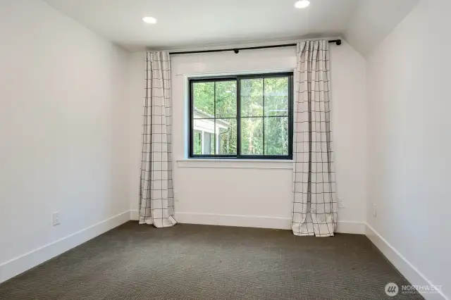 Bedroom #3 features Berber carpeting & a sizable walk-in closet with closet system and an access door to dormer storage. This room offers peaceful forest views.