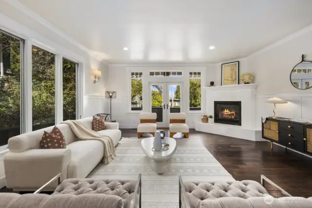Surrounded by windows, the expansive formal living room captures natural light throughout the day. Enjoy the warmth of the gas fireplace in winter, or step through french doors to the balcony for fresh air and neighborhood views.