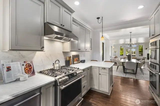 Oversized gas range with stainless hood.  Solid slab marble counters and backsplash walls.  Two ovens make holiday entertaining a breeze in this kitchen.  Large refrigerator and walk in pantry complete this kitchen.