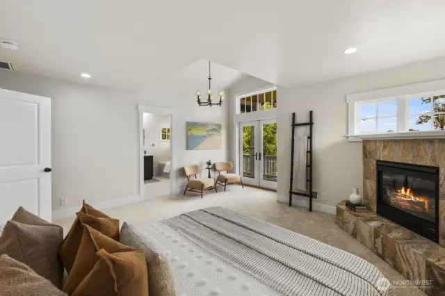 Primary bedroom with vaulted ceilings, gas fireplace, ensuite bathroom, and a very large walk out balcony complete with views.