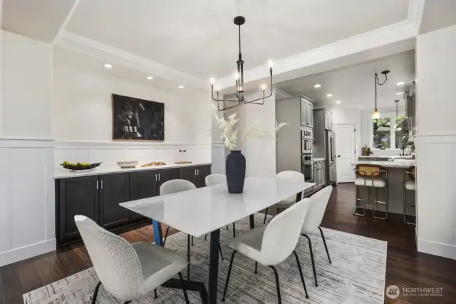 Dining space is perfect for entertaining.  Much larger dining tables can fit this space.  Tall ceilings with crown trim and wainscoting detailing along with custom built in storage.