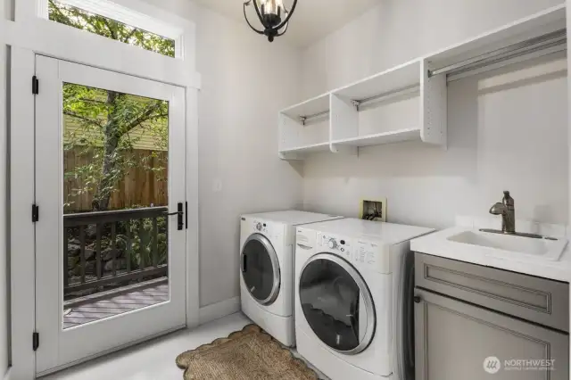 This laundry room is truly amazing!  Tall ceilings are an opportunity to personalize storage. Natural light floods this space through the large glass door from the backyard.