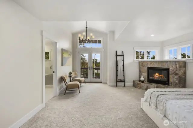 Primary bedroom with vaulted ceilings, gas fireplace, ensuite bathroom, and a very large walk out balcony complete with views.