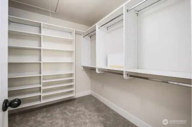 Primary bedroom walk in closet complete with storage organization.