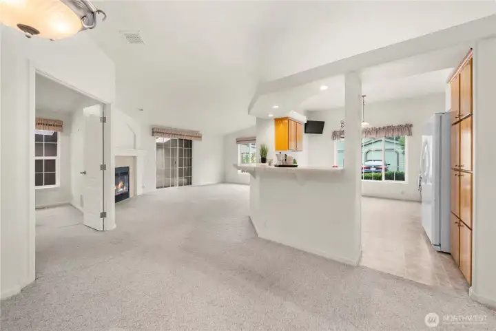 Great layout in this home! Seamless flow from the living room and dining area into the kitchen and bonus room beyond. On the left is the Primary Suite w/ French doors.