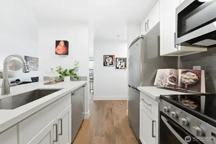 Updates include quartz countertops, new cabinetry, and stainless steel appliances.