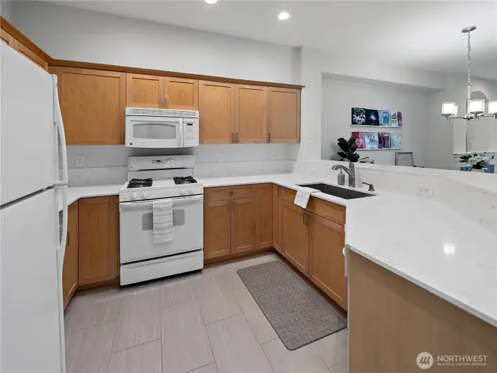Crisp and clean kitchen with ample counter space and bar seating.