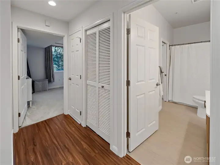A view of the primary bedroom and full bathroom. The washer and dryer are located in the middle closet, plus more storage space in the other closet to the left.
