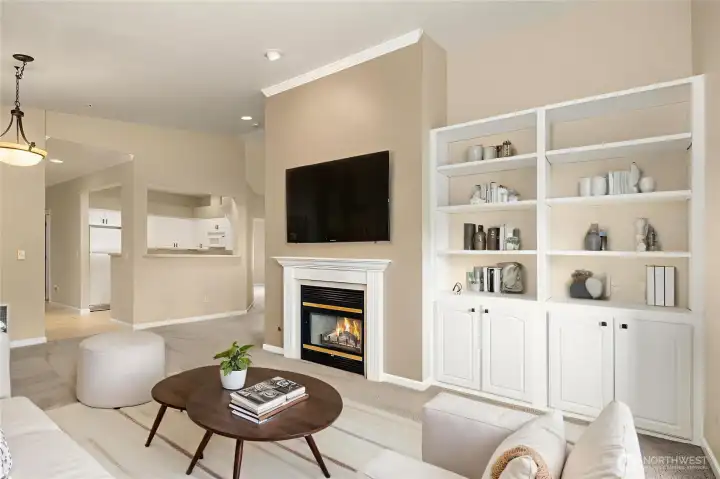 Vaulted ceilings with built in bookshelves and cozy gas fireplace - virtually staged