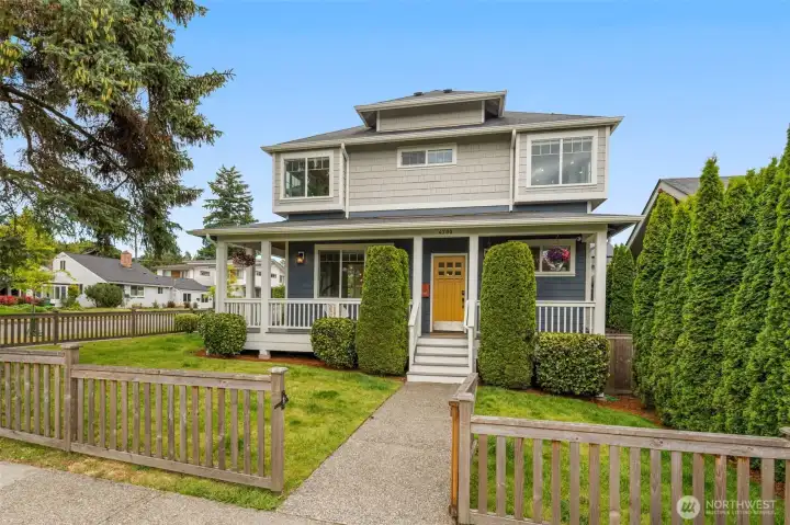 Home sits far back from the street behind a charming wood fence.