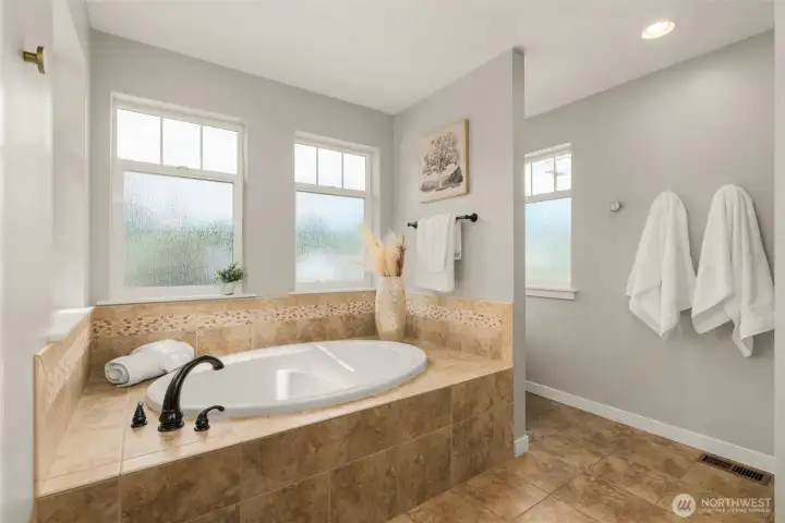 Oversized soaking tub in the primary suite bathroom.