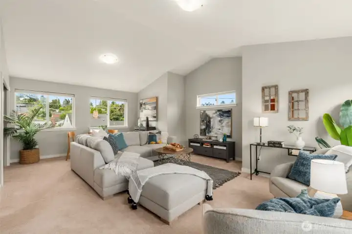 Upper level space currently staged as a rec room with vaulted ceilings.
