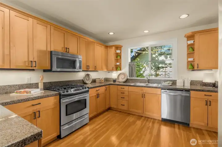 Spacious open kitchen with gas range and stainless steel appliances