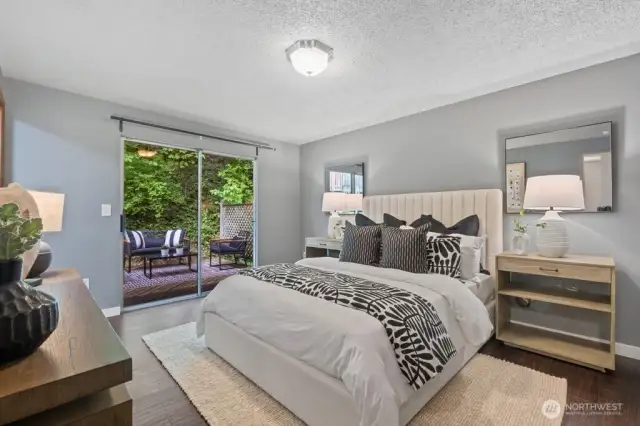King-sized primary suite with access to the multi-level deck and backyard
