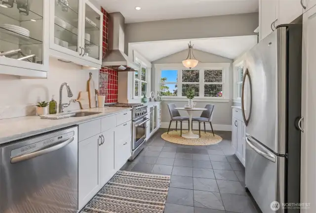 Beautiful kitchen remodel featuring marble countertops, slate floors and stainless-steel appliances, with natural light pouring in throughout.
