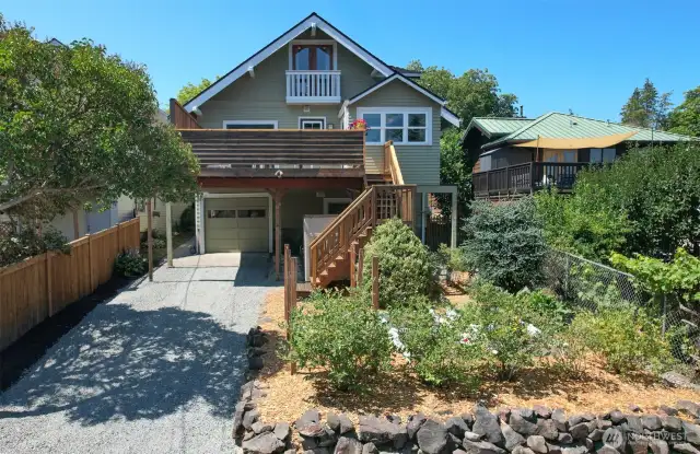 A great view of the primary suite balcony and private view deck with stairs to the back yard and garden. A bounty of blueberries this year!