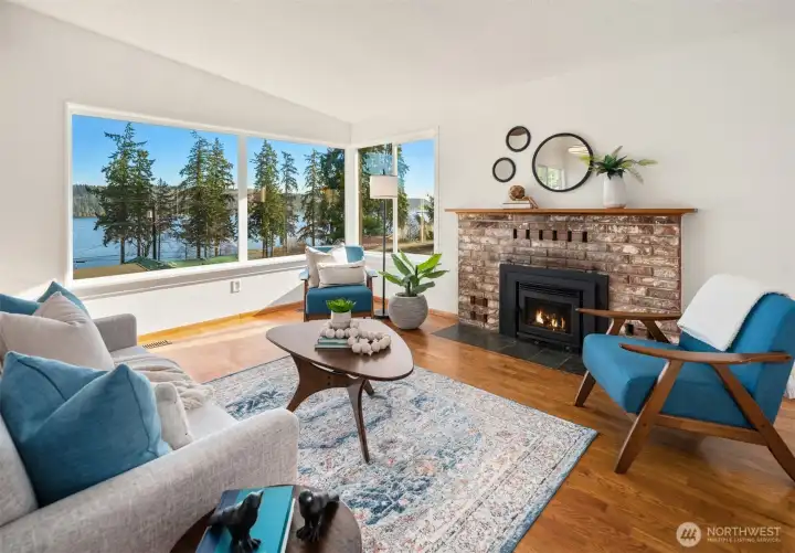 Corner grouping of picture windows and a wood burning insert brick fireplace.