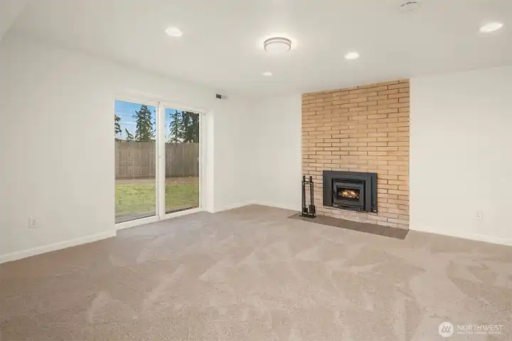 Large downstairs bonus room with sliding doors and wood burning fireplace.