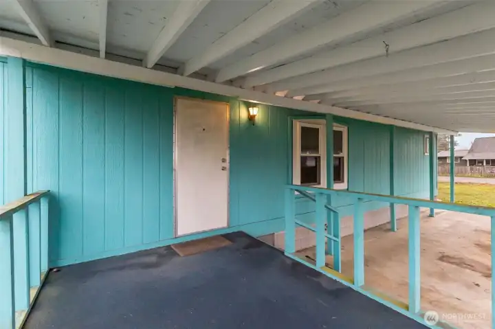 Paved carport and covered front porch keeps you out of the weather upon arriving home.