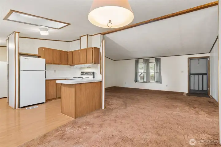View from dining room, with kitchen to the left and living room straight ahead. 2 bedrooms and a full bath are to the right of this view.