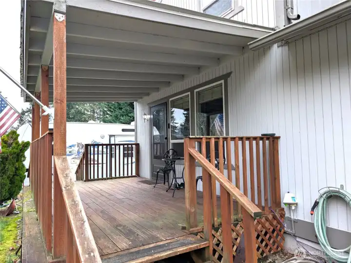 Covered front deck with access to driveway, RV parking & interior.