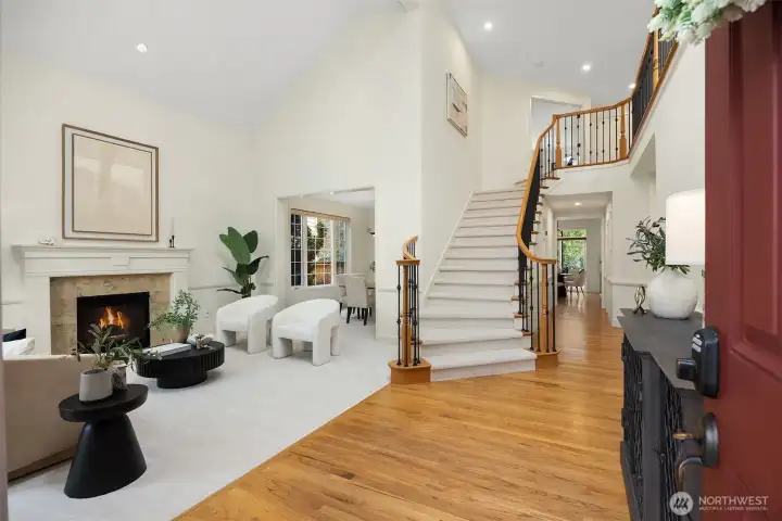 A grand double-door entry opens to a light-filled interior with a soaring two-story ceiling,  grand staircase, rich hardwood floors, and an exceptional floorplan. The heart of the home unfolds as a gracious great room, where the kitchen, casual dining area, and family room, with gas fireplace, come together in a seamless, connected setting.