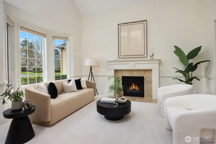 The formal living room features a vaulted ceiling, gas fireplace and a beautiful bay window.