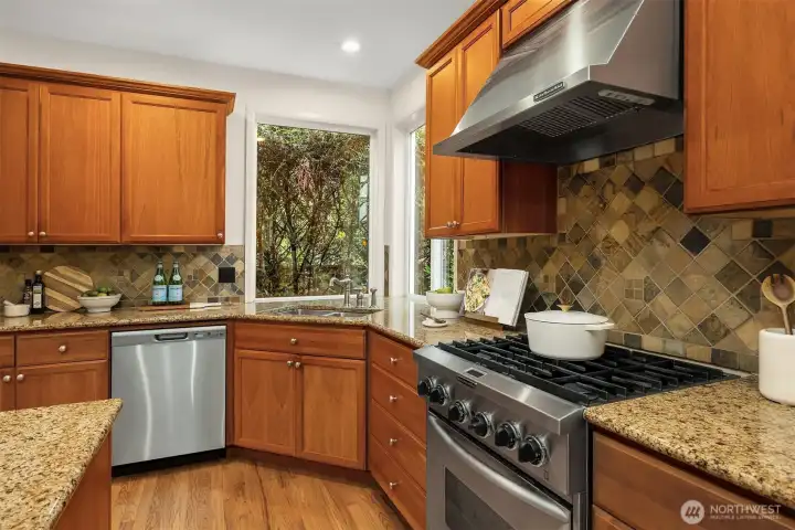The chef’s kitchen anchors the heart of the home, appointed with custom cabinetry, a spacious center island, granite slab countertops, and stainless-steel appliances, well-suited for both casual meals and hosting gatherings.