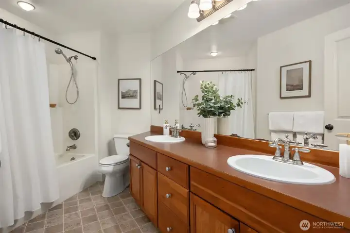 Upper level bathroom with tub/shower and dual sinks.