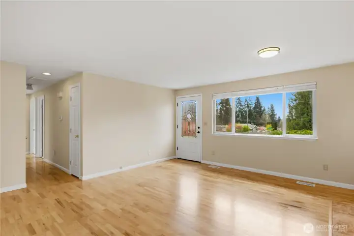 Light filled living space with gleaming hardwood floors.