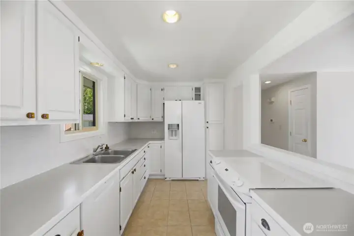 Light filled kitchen with ample storage, tile backsplash and window looking out to the back yard.