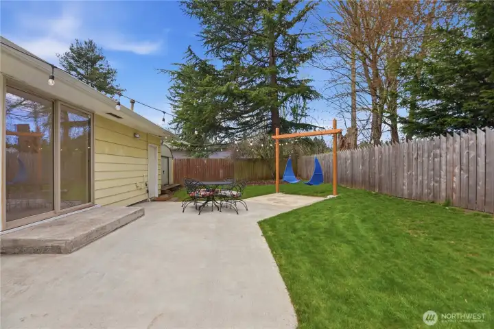 Fully fenced yard with patio and level lawn.