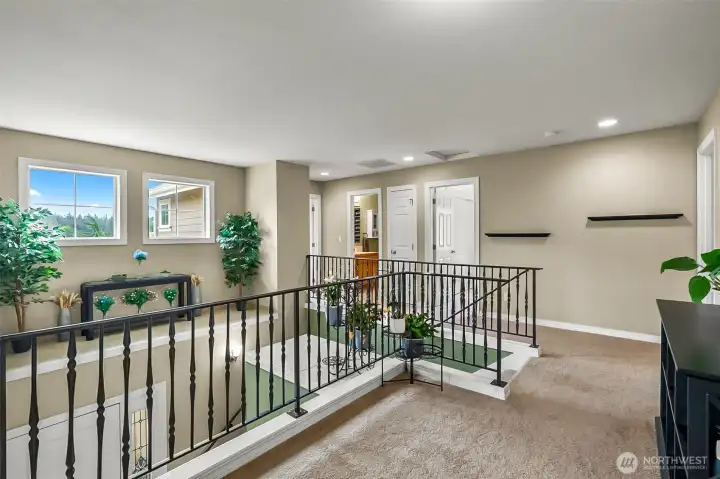 upstairs is wide and open hallway, elegant metal railings