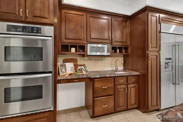 The kitchen features high end stainless appliances including double-ovens and a large fridge The kitchen features high end stainless appliances including double-ovens and a large fridge
