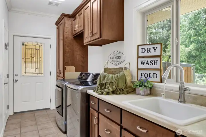 The laundry room is adjacent to the kitchen and features a large sink The laundry room is adjacent to the kitchen and features a large sink