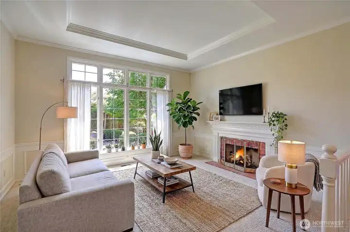 Virtually staged living room with fireplace, full of light and views of the gardens