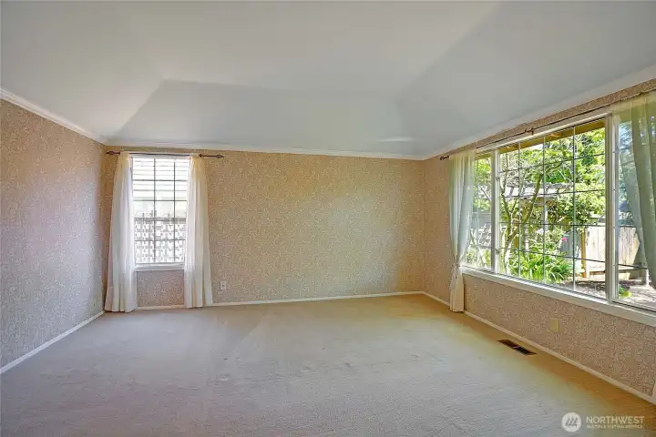 Primary bedroom with lots of light from oversized windows looking out into the gardens