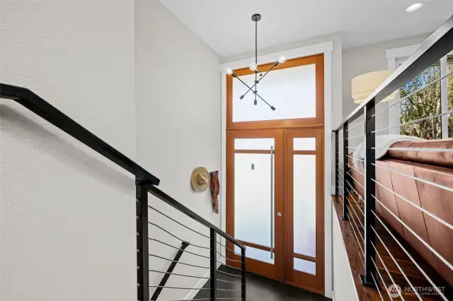Metal handrails with stainless steel cables, modern lighting and natural light fills this home