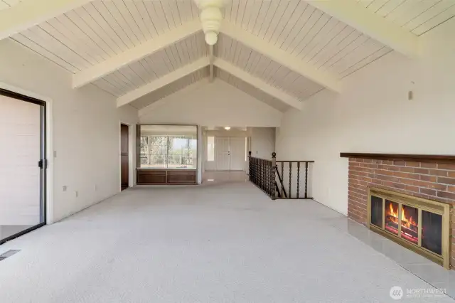Living room with vaulted ceiling and access to deck