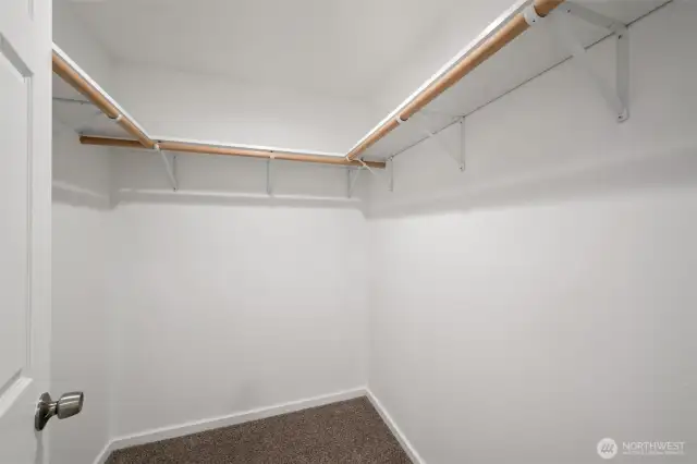 The walk-in closet in the primary bedroom is spacious and there is a lot of hanging space.