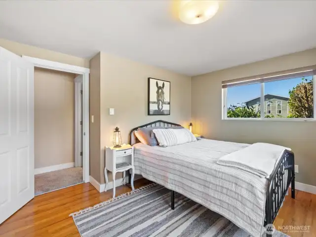 Spacious Primary Bedroom with wood floors, closet & view windows.