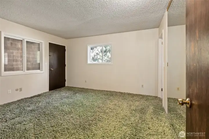Primary bedroom upstairs with door to private covered balcony.