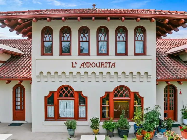 Charming arches and red-tiled eaves, a warm and timeless welcome to historic L’Amourita—Seattle’s cherished 1909 treasure.