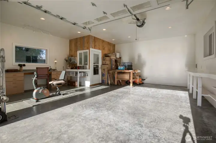 Fully insulated and sheetrocked garage with recessed lighting, heat, workshop, and ventilated paint room. Perfect space for a shop, fitness center or crafting.