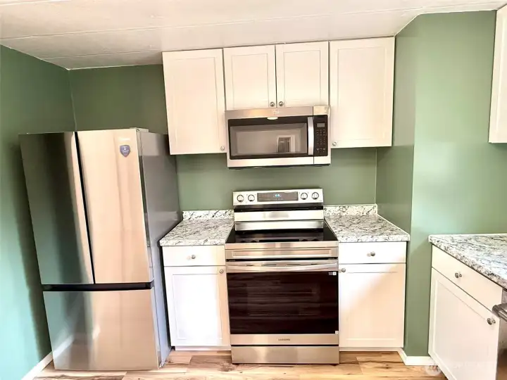 Kitchen with new refrigerator, stove, microwave, and cabinets